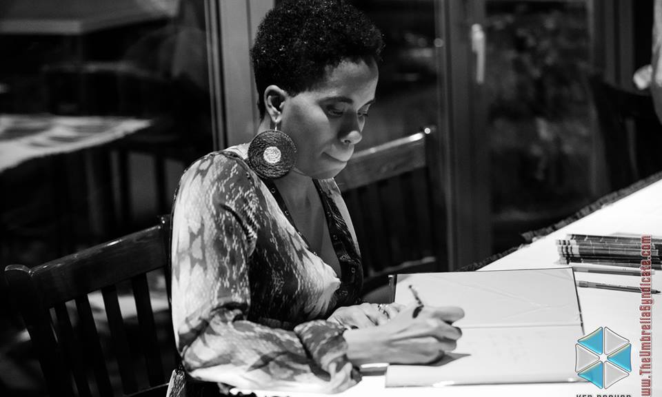 Alyscia Cunningham signing copies of her book, Feminine Transitions, at her book launch party.